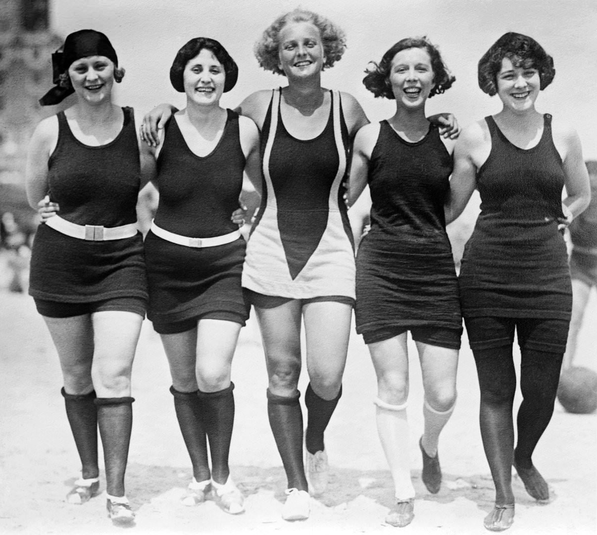 #21 Five women walking arm-in-arm on the beach wearing wool bathing suits, 1925