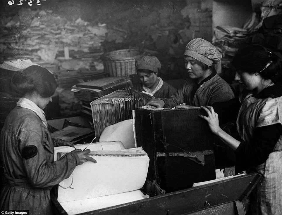 As part of the war effort, old paper had to be reused. These women are pulling apart old ledgers belonging to the London &; South West Railway.