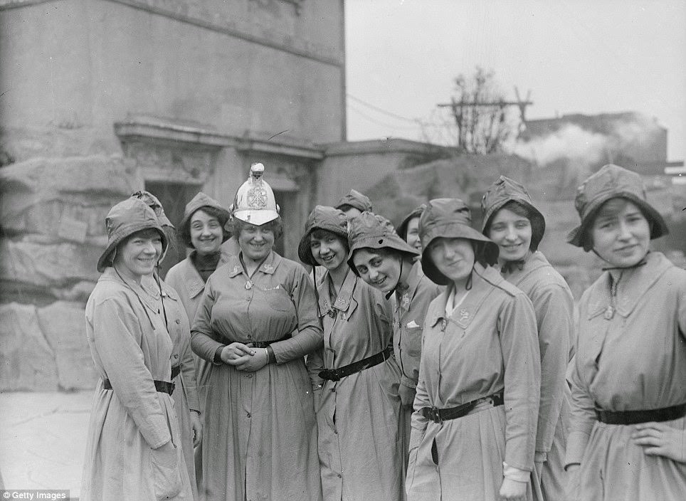 #22 Members of the Women’s Fire Brigade with their Chief Officer photographed in their uniforms beside an extinguished fire in March 1916.