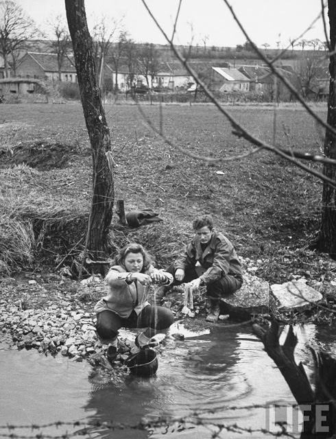 #40 Ernest Kreiling teaching his bride how he washed in socks in stream during the war.