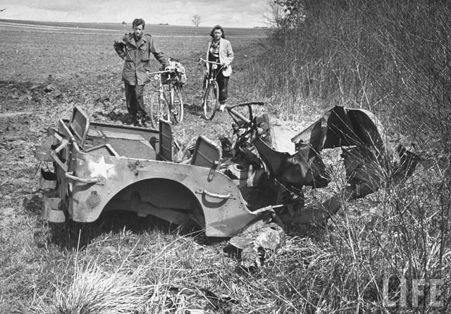 #16 Ernest Kreiling and his bride looking at a wrecked jeep during tour of battlefields.