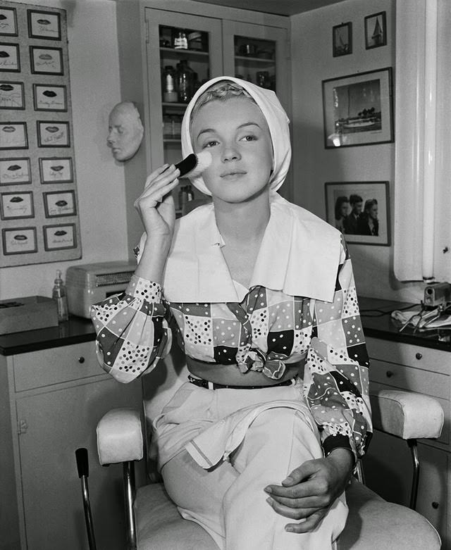 #23 Marilyn preps her skin with a skin brush before applying makeup, 1948