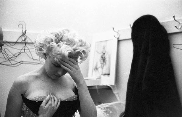 #58 This photo captures a moment of frustration during a costume fitting, 1955