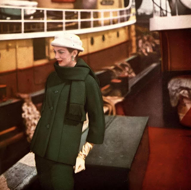 #50 Carmen in deep green basket-weave wool suit with longer jacket and fringed scarf collar by Monte Sano & Pruzan, hat by Mr. Arnold, 1958.