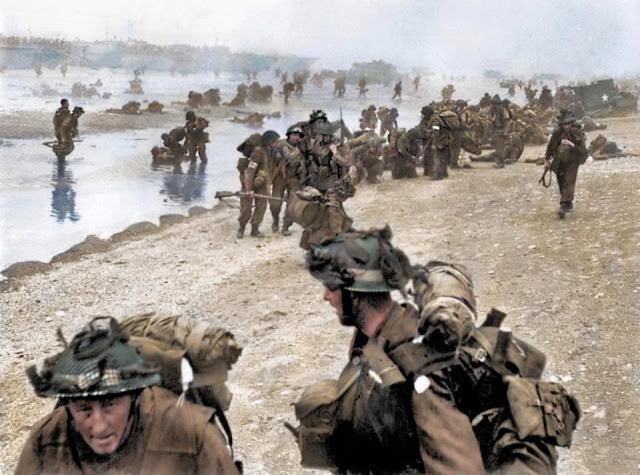 #16 British troops show their true grit as they help injured comrades onto Sword Beach.