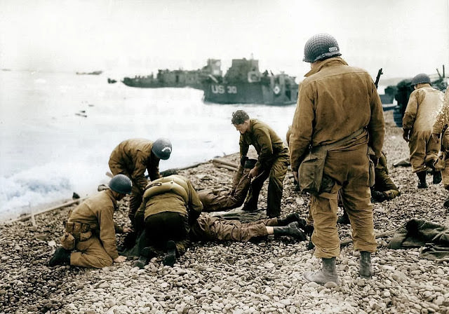 #43 Allied troops exiting a landing craft in trucks on a beachhead during the D-Day landings in Normandy, France.