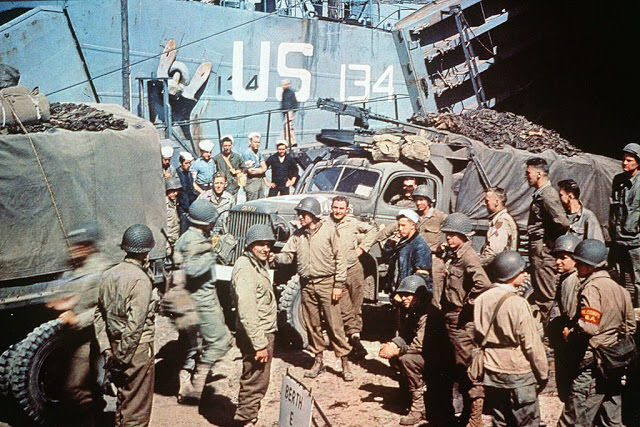 #45 UTAH BEACH, FRANCE: US soldiers gather around trucks disembarking from landing crafts shortly after D-Day.