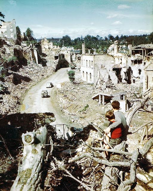 #53 Operation Overlord Normandy, Two children are watching an American Army jeep driving through the ruins of Saint-Lo.