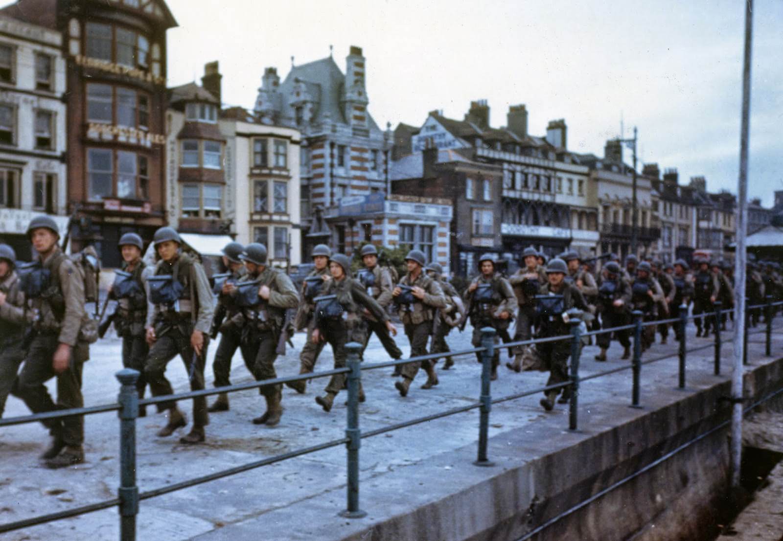 #56 These American troops are marching through the streets of a British port town on their way to the docks where they will be loaded into landing craft for the big assault.