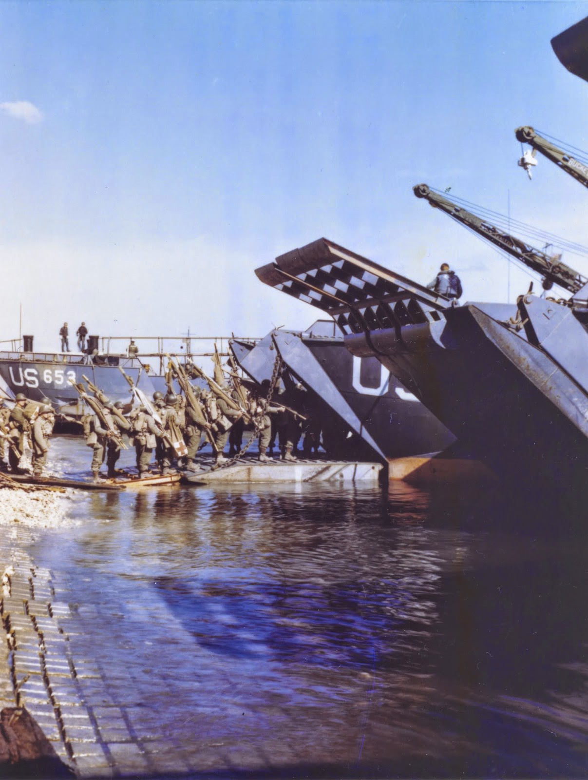 #60 Medics and litter bearers going up the ramp of an LCT which will take them to France for the assault against Hitler’s Europe.