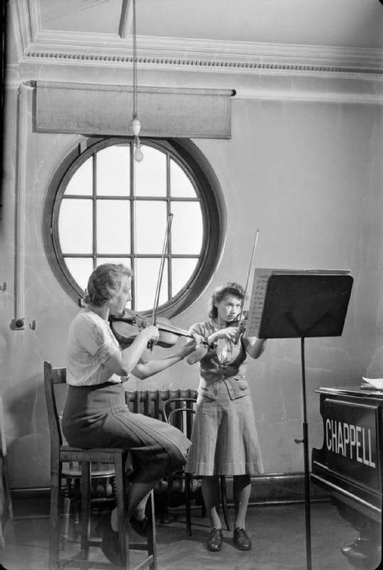 #15 Miss Winifred Small (left) is a BBC soloist and professor at the Royal Academy of Music. Here she can be seen giving a violin lesson to a female first year student at the Academy, 1944.