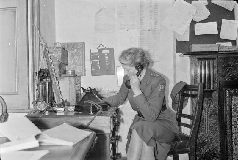 #9 A woman of the American Ambulance Great Britain receives a telephone call requesting their attendance at an incident, 1944.