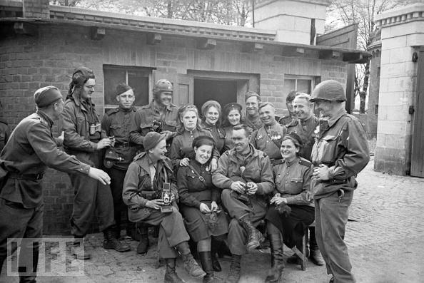 #54 American soldiers and war correspondents join male and female Red Army soldiers in Torgau, Germany, on April 27, 1945, toward the end of the European war.
