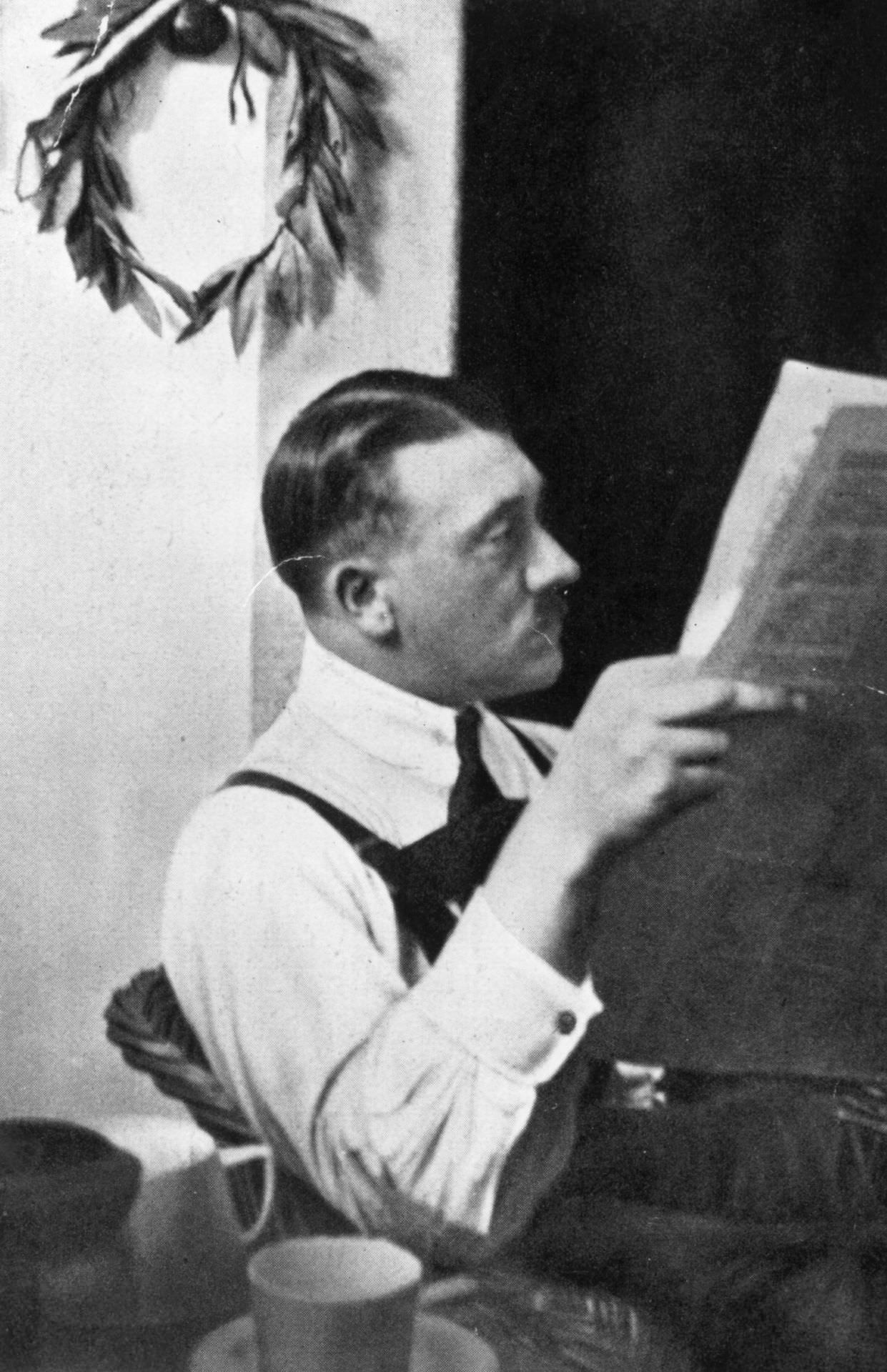 #42 Adolf Hitler sits reading a paper during his imprisonment in Landsberg Jail, 1924