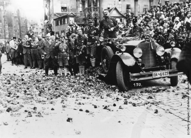 #20 Adolf Hitler drives along a flower strewn road after a rally at Nuremberg, 1929