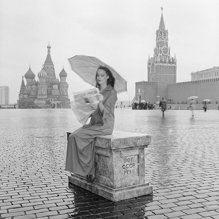 #13 Jerry Hall reading a paper in Red Square wearing Yves Saint Laurent Rive Gauche, 1976