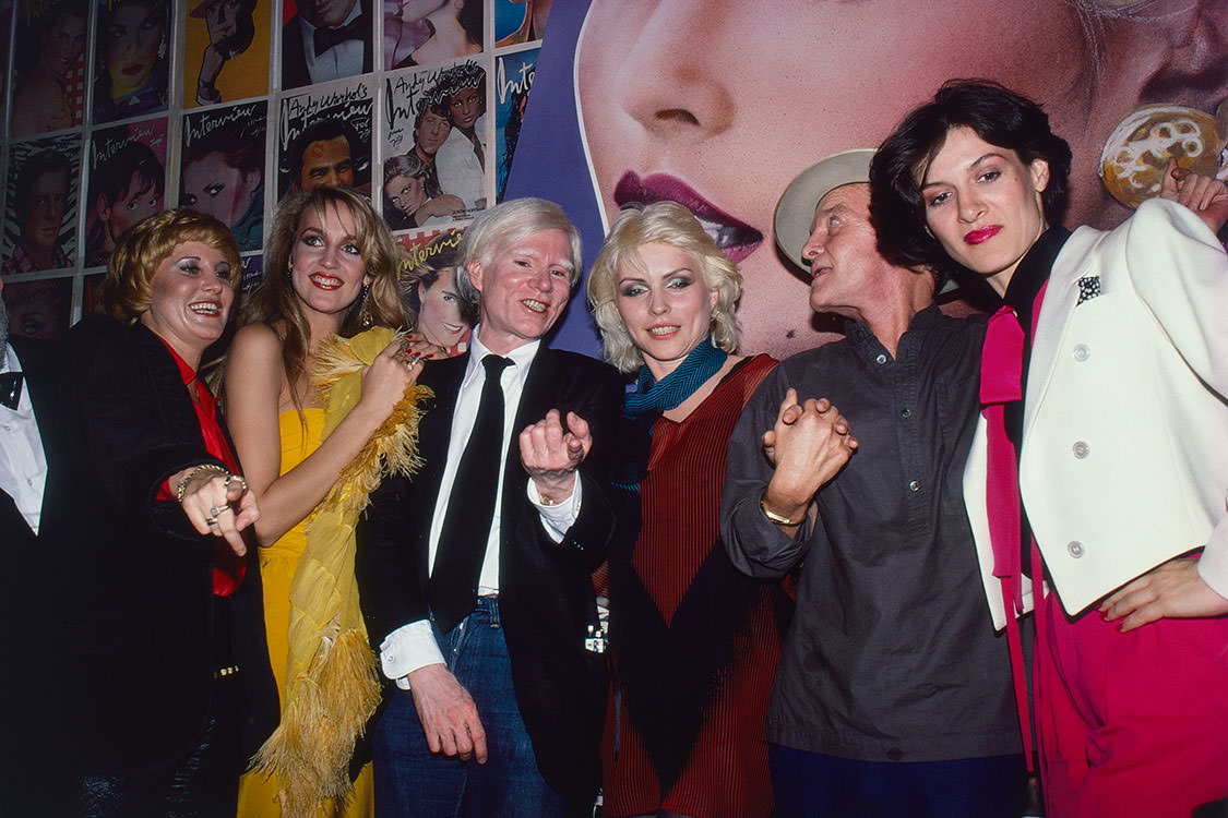 #47 Jerry Hall with artist Andy Warhol, singer and songwriter Debbie Harry, novelist Truman and Paloma Picasso in New York City, 1979