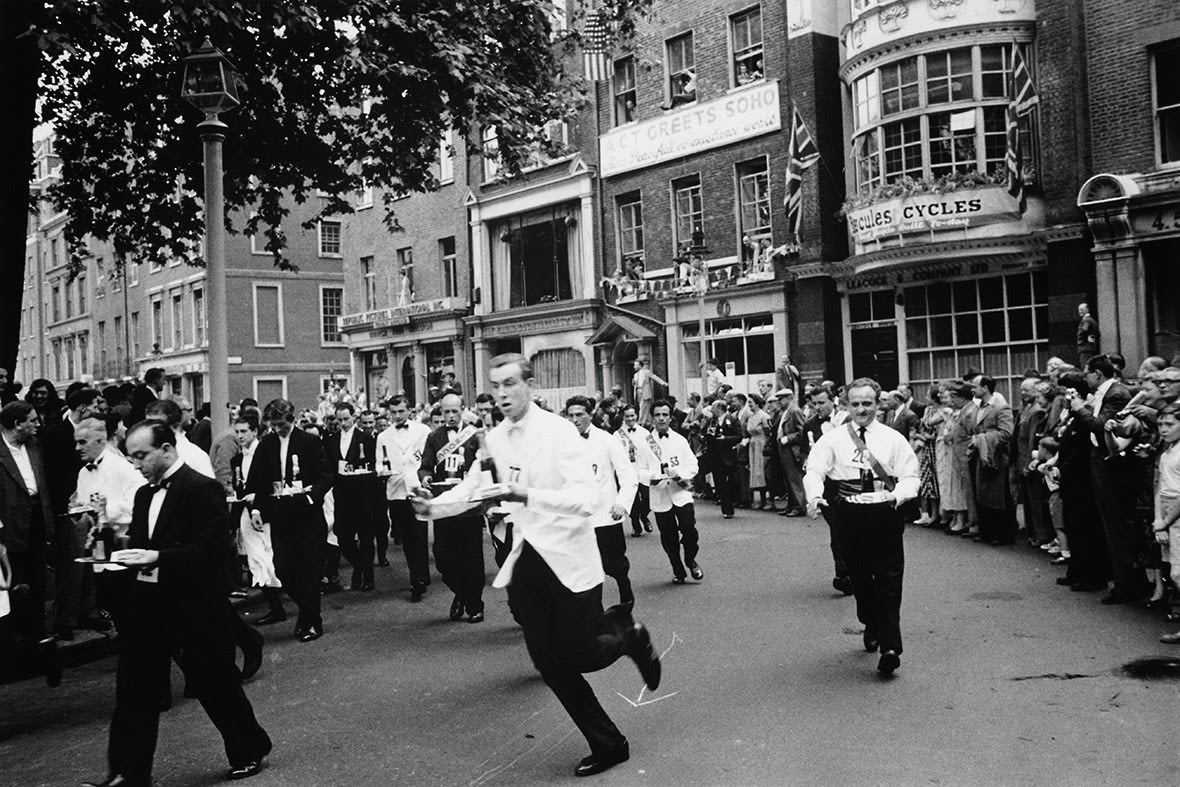 #12 Waiters carrying half bottles of champagne set off on the annual waiters’ race from Soho Square to Greek Street, 1955