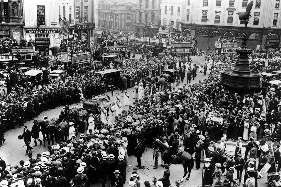 #3 Crowds watch the cortege of suffragette Emily Davison, who was killed by the King’s horse at the Derby, passing Eros at Piccadilly Circus, 1913