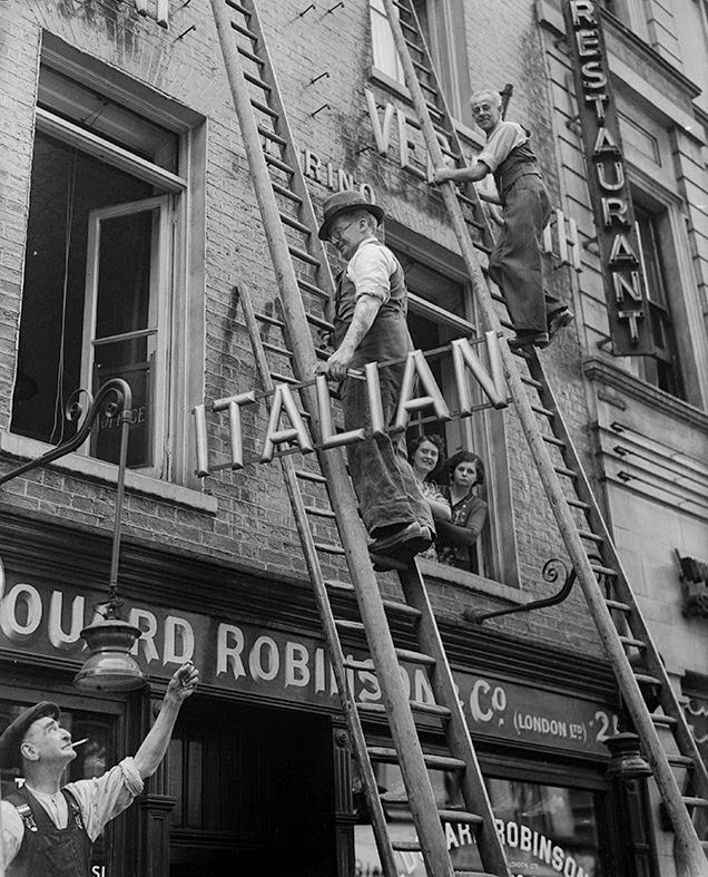#8 A shopkeeper removes the word ‘Italian’ from the sign above his restaurant in Soho, after anti-Italian riots throughout Britain, 1940