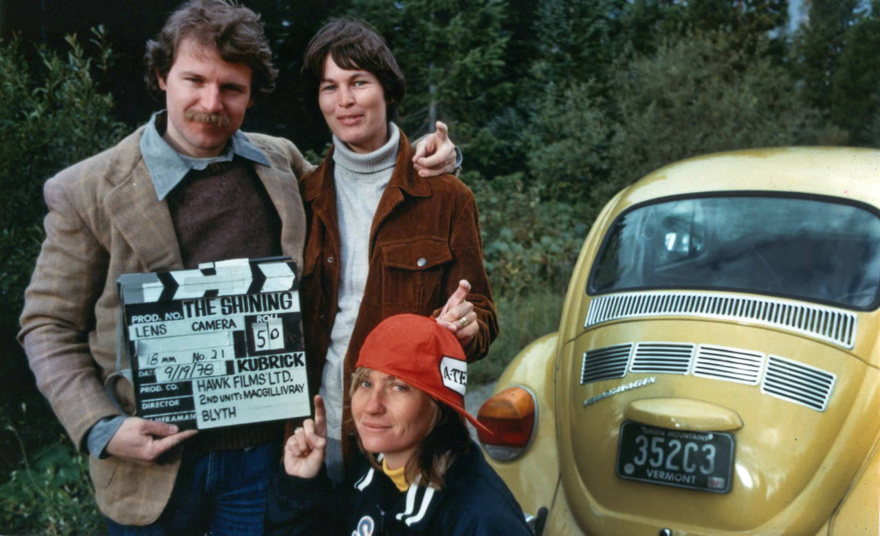 #10 2nd Unit camera operator Jeff Blyth, Jeff’s wife, and their camera assistant doubling for the Torrance family in many unused shots of the car and wearing costumes from the film. Note their “Tony” finger poses.