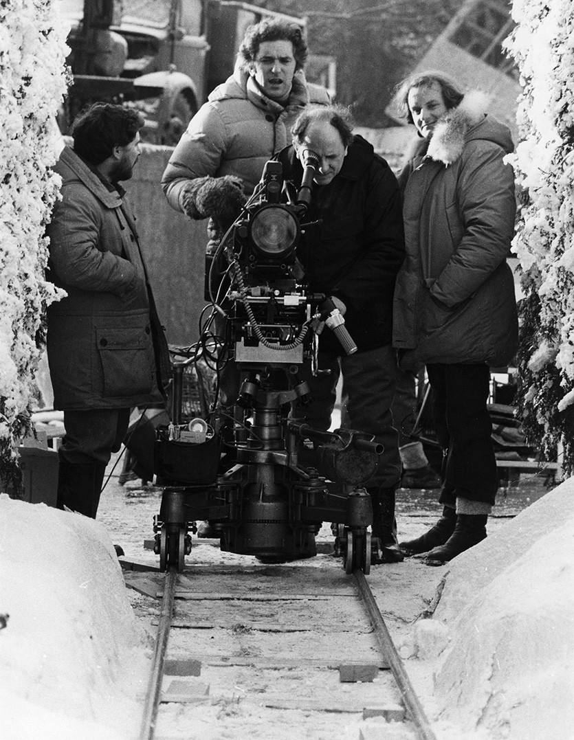 #43 Grip Dennis Lewis, Assistant Director Brian Cook, Camera Operator Kelvin Pike, and Camera Assistant Douglas Milsome set up a shot for in the exterior hedge maze set on the backlot of Elstree Studios.