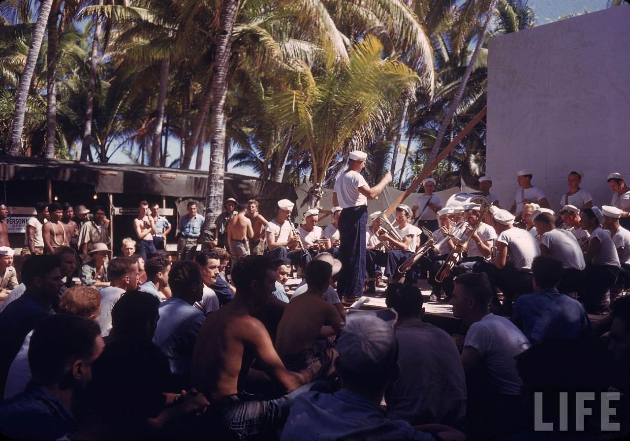 #34 US Navy band playing small concert for servicemen and curious locals during WWII.