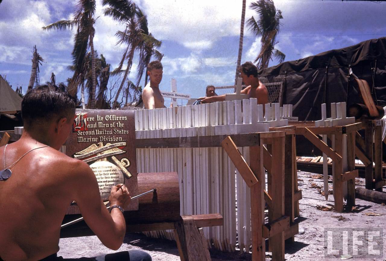 #9 Men preparing grave markers while another finishes an ornate sign to adorn a US Marine 2 Div. graveyard on Tarawa during WWII.