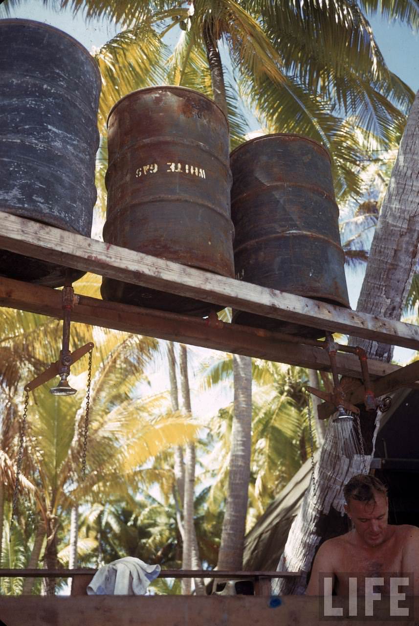 #25 Soldier using a makeshift shower on Tarawa during WWII.