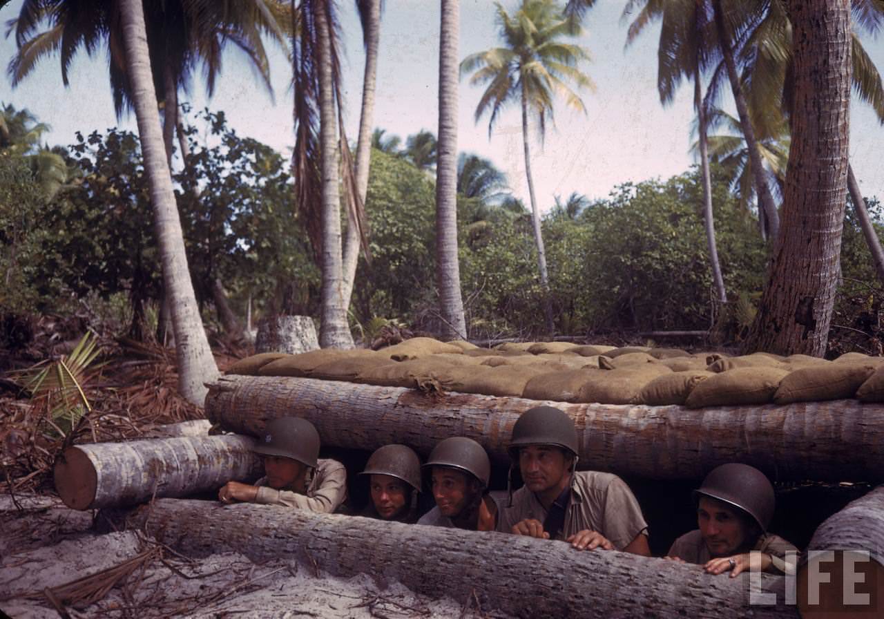 #26 Group of American soldiers peering from a reinforced bunker on Tarawa during WWII.