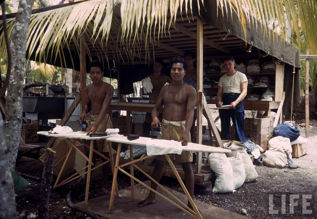 #27 Native men ironing GI clothes on Tarawa during WWII.