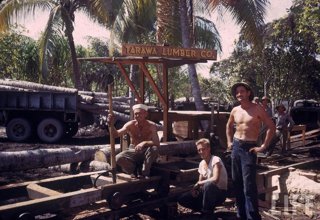 #32 Trio of American servicemen taking a break from gathering lumber during WWII. (note sign on truck naming it the TARAWA LUMBER CO.)