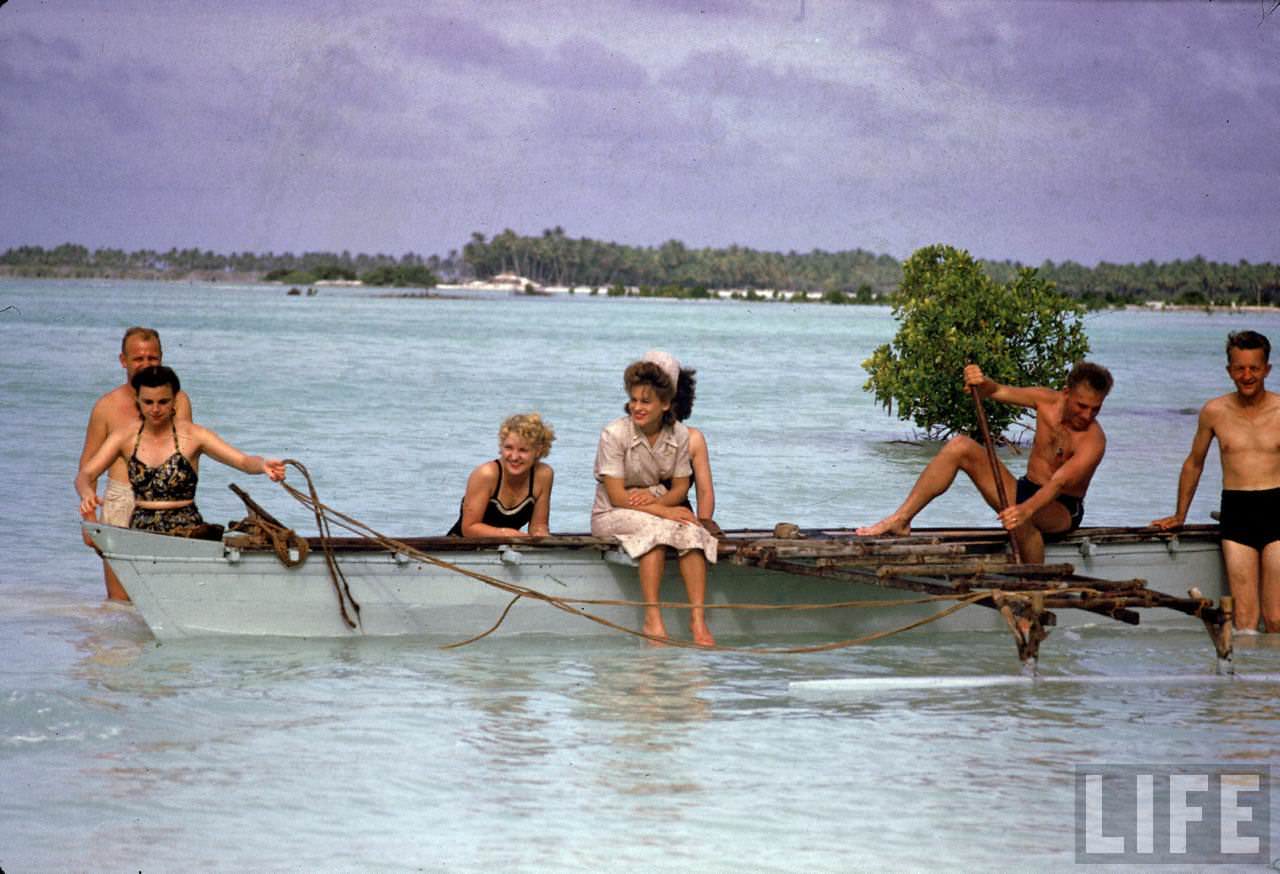 #7 American servicemen and women relaxing on a boat ride along the shores of the Tarawa Atoll during WWII.