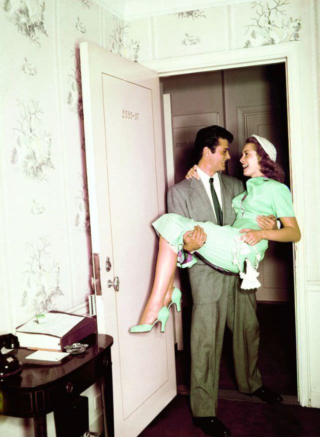 #8 Tony Curtis carries new bride Janet Leigh over the threshhold, 4 June 1951