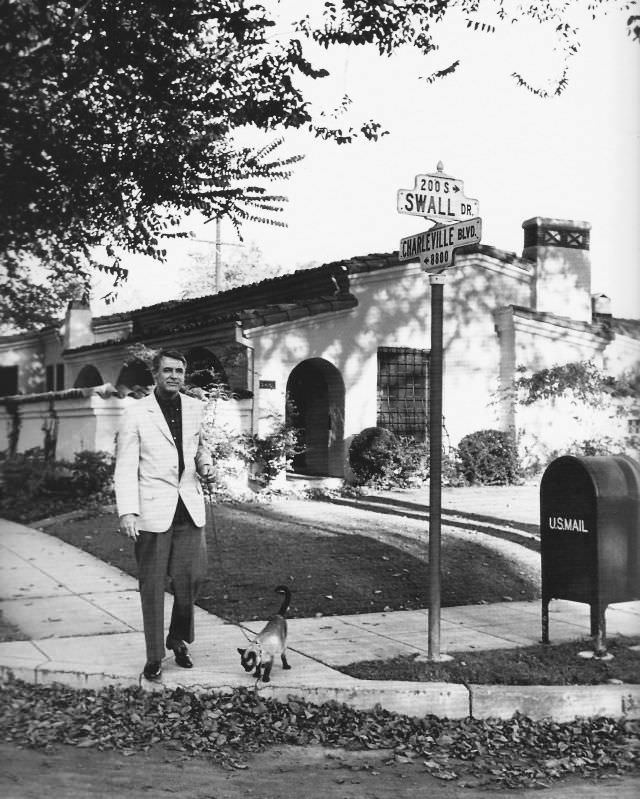 #7 Cary Grant walking his Siamese cat in Beverly Hills, 1955
