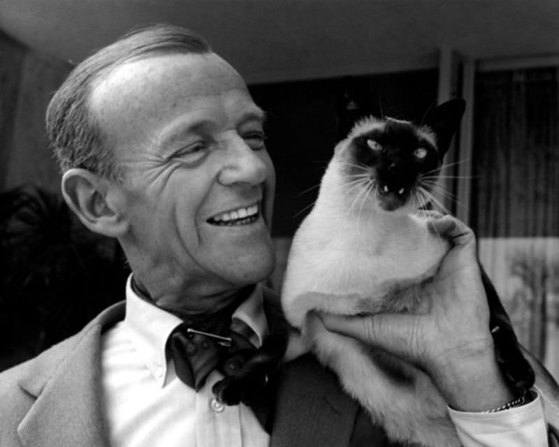 #10 Fred Astaire with his Siamese cat, ‘Carlyle,’ on his shoulder, 1962