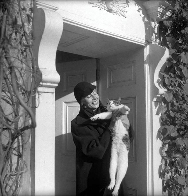 #24 Greta Garbo with Cecil Beaton’s cat at his home, Reddish House, in Broadchalke, England, 1951