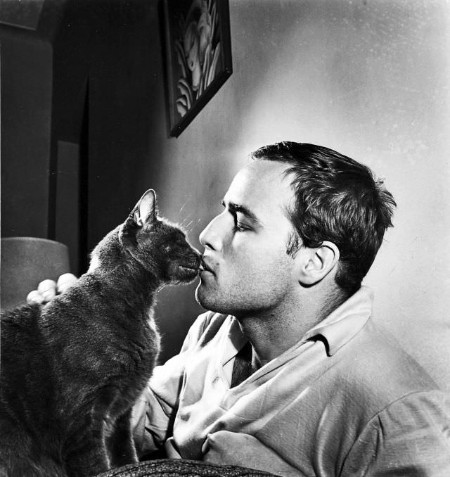 #33 Marlon Brando kissing a cat at his home, 1950s.