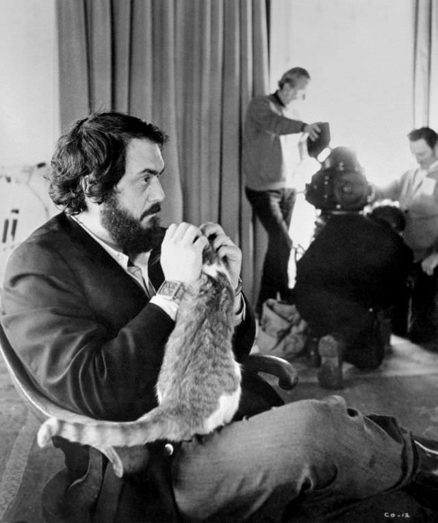#39 Stanley Kubrick sitting in a chair playing with a cat on the set of ‘A Clockwork Orange,’ 1972