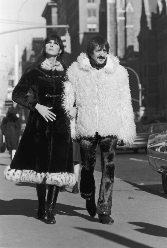 #5 Sonny Bono, in a Mongolian lamb’s wool jacket, and Cher, in a long fur overcoat trimmed with leopard fur, walk arm-in-arm down the sidewalk, New York City. Photo by Jack Robinson.