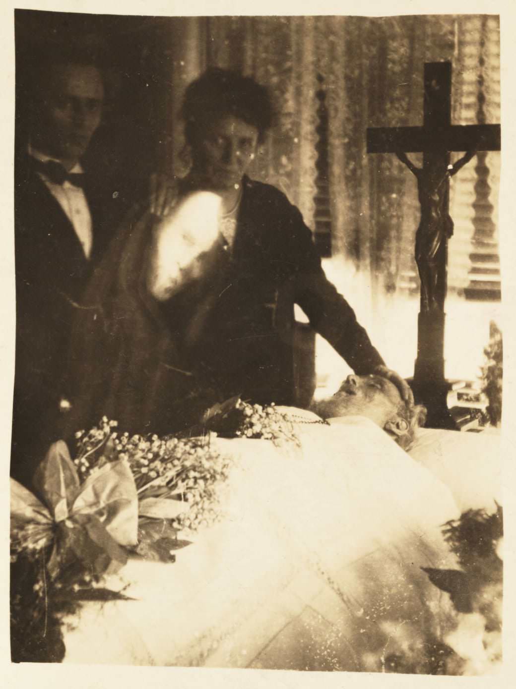 A ghostly apparition caught on film during a wake, circa 1920