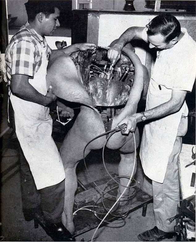 Two engineers fix a Disney animatronic