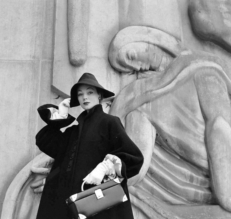 #14 Ivy is wearing Givenchy’s big-sleeved coat of navy wool with new wrist-ruffle cuffs and Garbo-slouch hat, Paris, February 1952