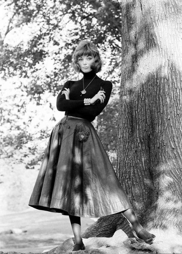 #48 Ivy wears traditional “English bobby” oilskin cape as a skirt, imported by David Seiniger of Empire Imports, 1958