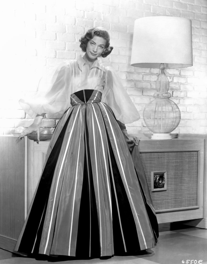 #34 Looking elegant in a billowy blouse and high-waist full skirt for a studio portrait, 1955.