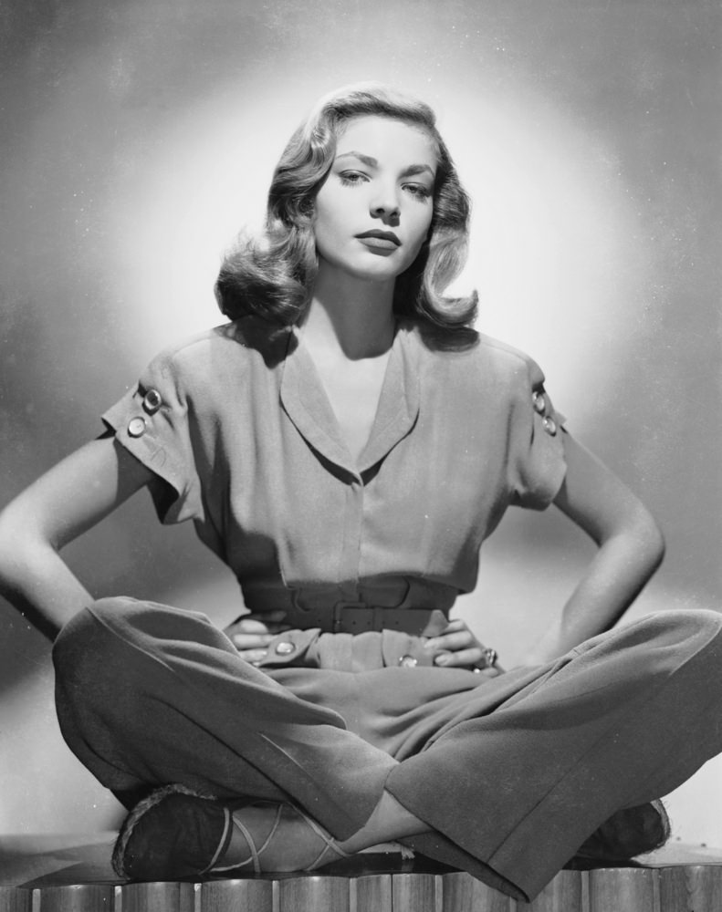 #16 Sitting cross-legged with her hands on her hips in a jumpsuit, 1944.