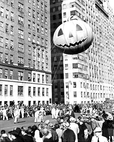 Watchers lean from windows in 1945 as a mammoth pumpkin passes by in the Macy’s Thanksgiving Day Parade.
