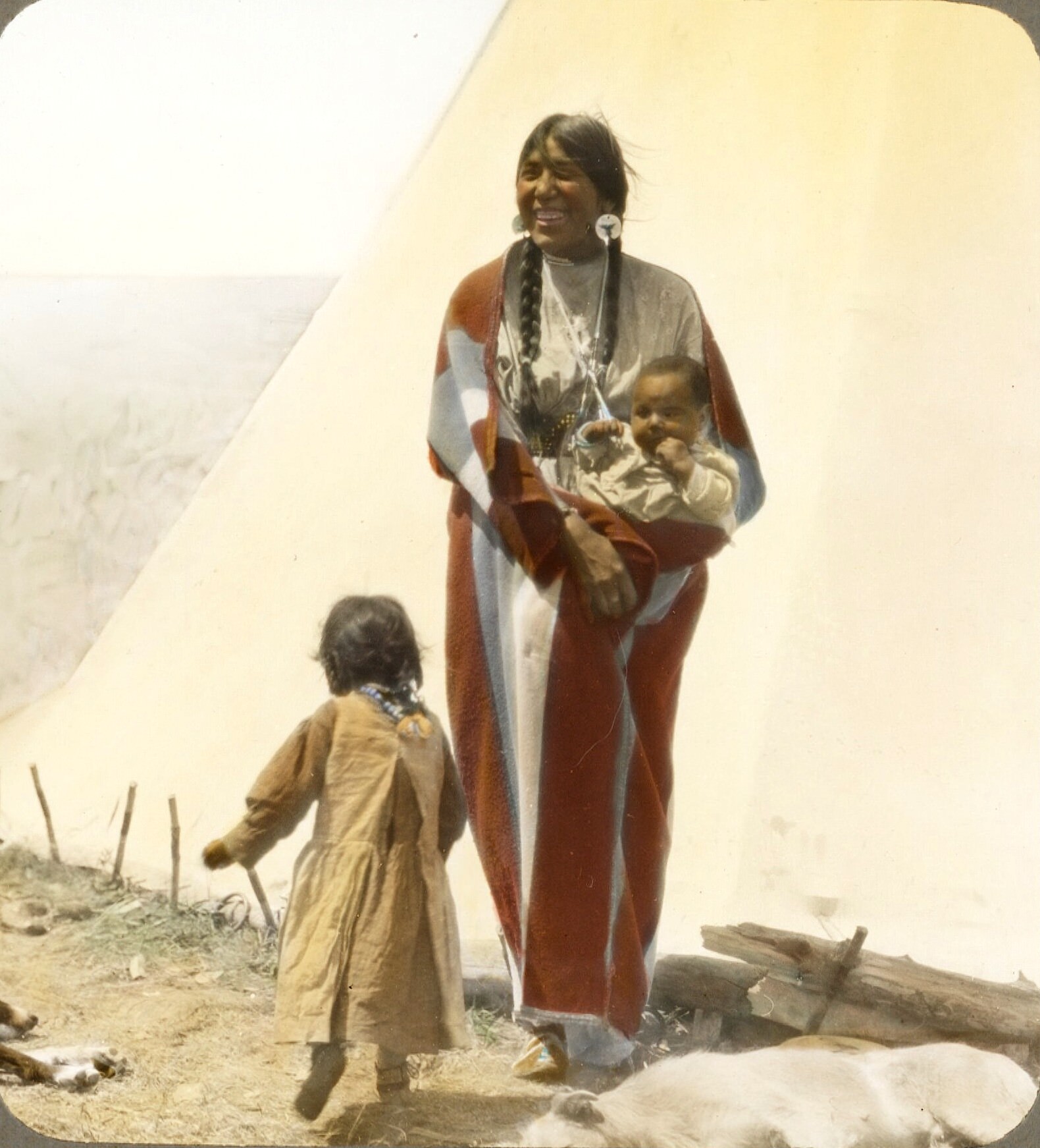 “Coming Running”. Blackfeet woman with children. Montana. Early 1900s. Glass lantern slide by Walter McClintock.