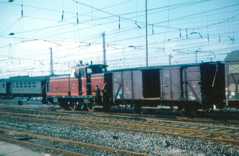 #4 Heilbronn. A V 60 diesel locomotive is moving an old two-axle freight car in the Heilbronn station yard