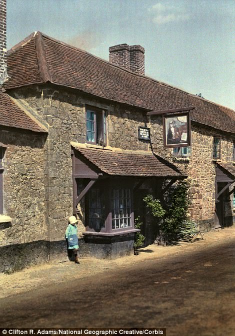 #22 A child stands by The Cat and the Fiddle Inn in Exeter in 1931
